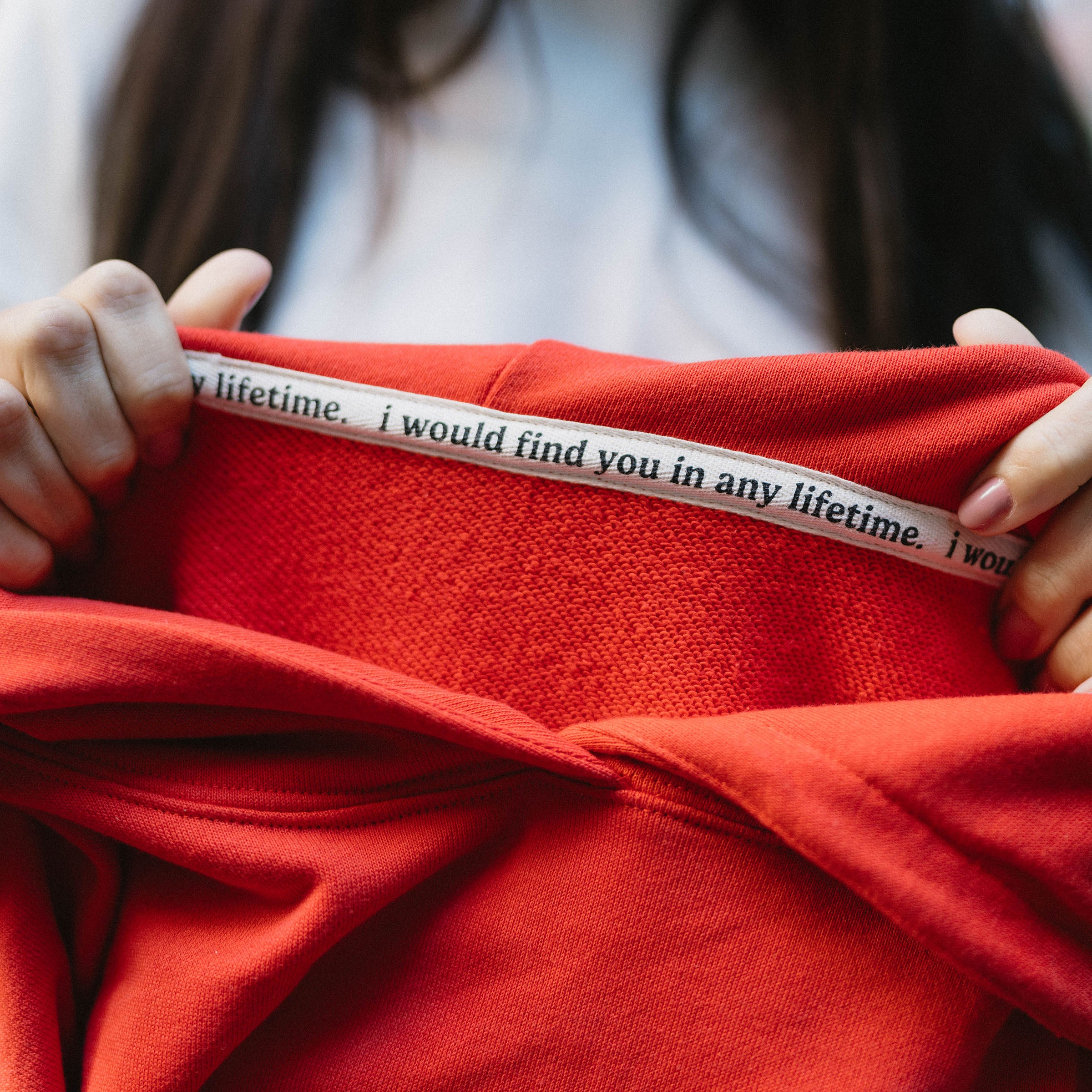 Twill on inside of red hoodie reading "i would find you in any lifetime."