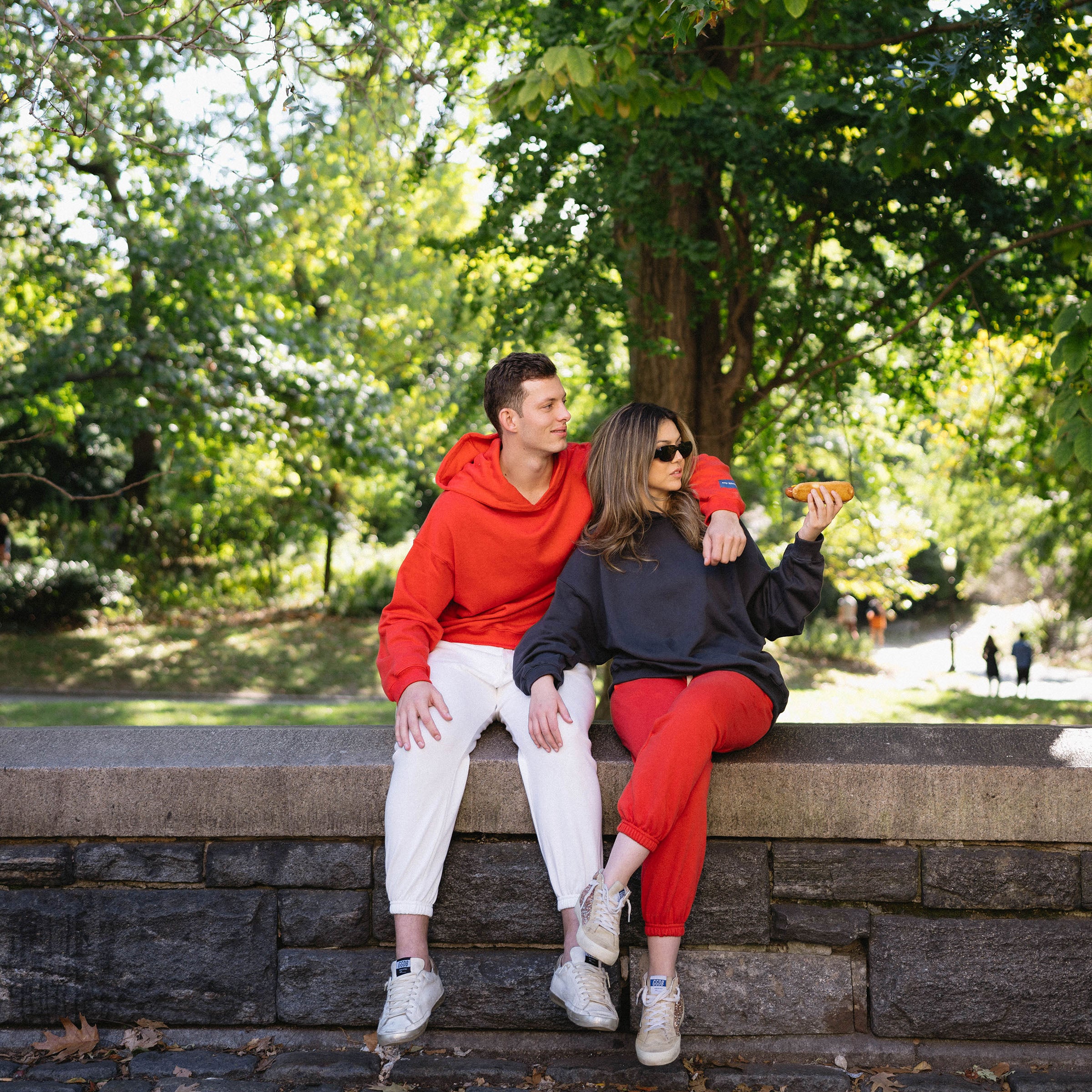 Miranda and Alex sitting outside Central Park in their mismatched hoodies. 